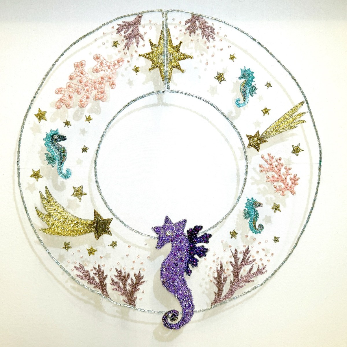 The photonic emergence collar: a hand-embroidered collar on silk organza with a purple seahorse, blue creatures and pale coral forms.