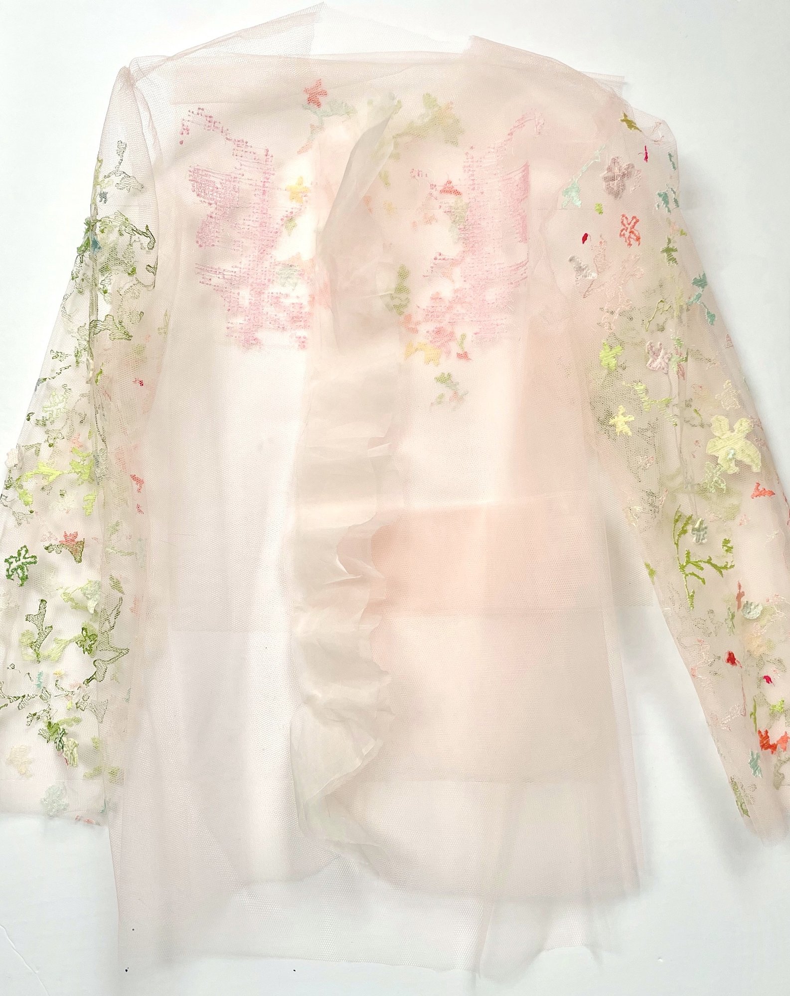 A jacket of pale pink tulle and organza, its sleeves and back machine-embroidered with blossoms and leaves in green, pink and coral.