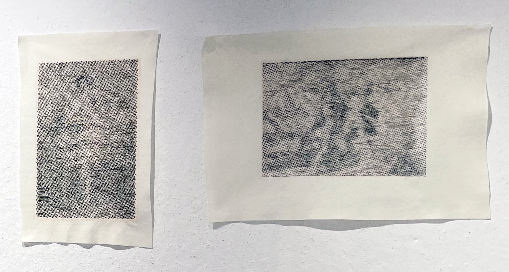 Two machine-stitched dot drawings pinned side by side on a white wall.