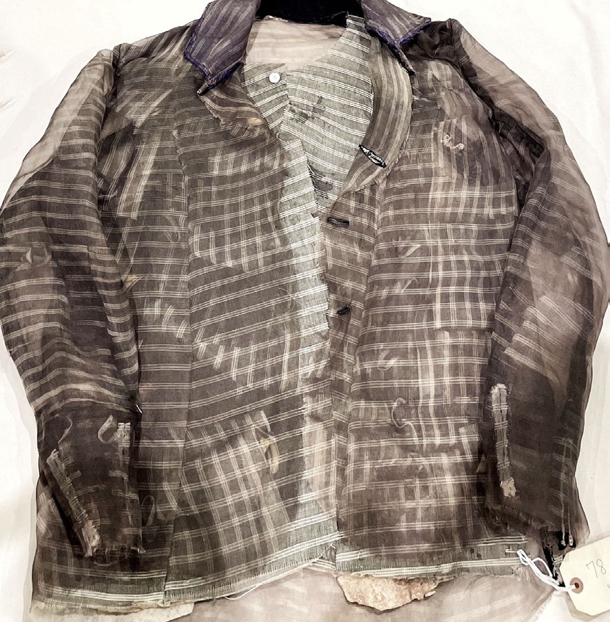 A jacket of translucent grey-striped silk organza, bleached and stained, with a button and tie.