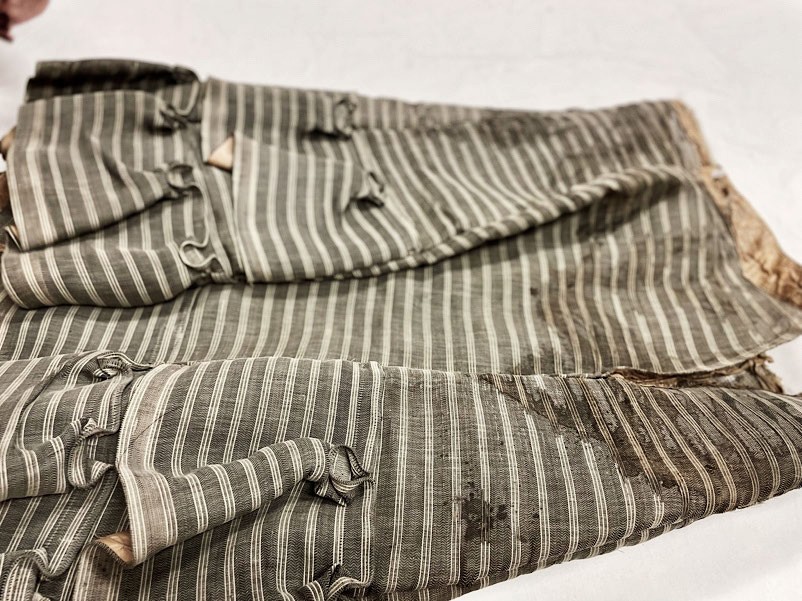 The original deaccessioned horsehair petticoat in grey stripes, crumpled.