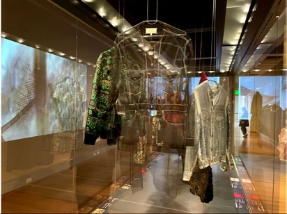 The Sensing Fashion gallery, with garments on forms and projected video on the walls.