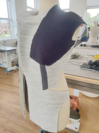 The chest canvas pinned to a jacket front on the stand.