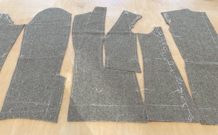 The cut components of the jacket laid out on the floor.