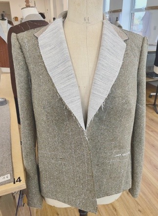 The basted jacket body on the stand with balance lines marked.