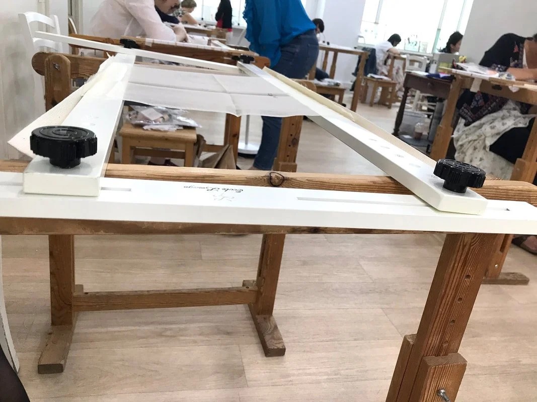 The atelier: slate frames on trestles in a bright classroom.