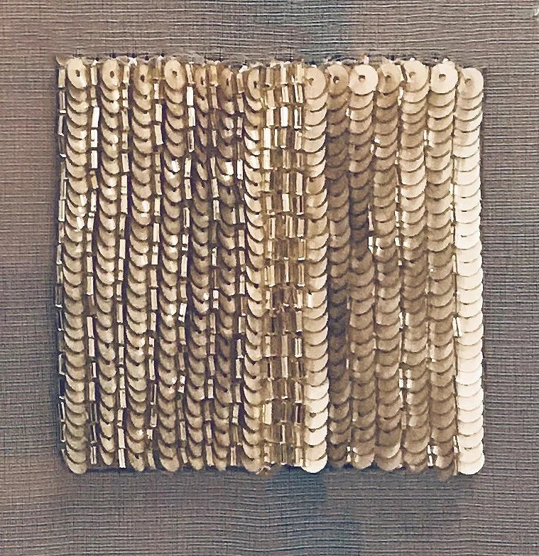 Overlapping columns of gold paillettes.