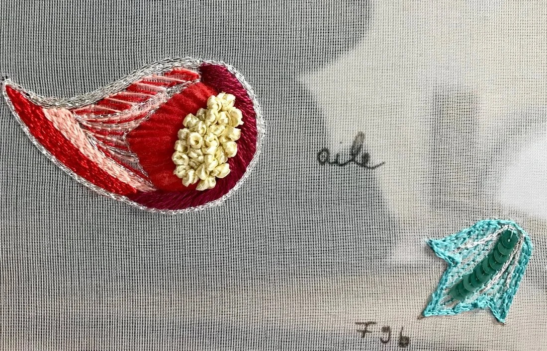 A red paisley motif with a cluster of cream French knots, and the pencilled word aile.