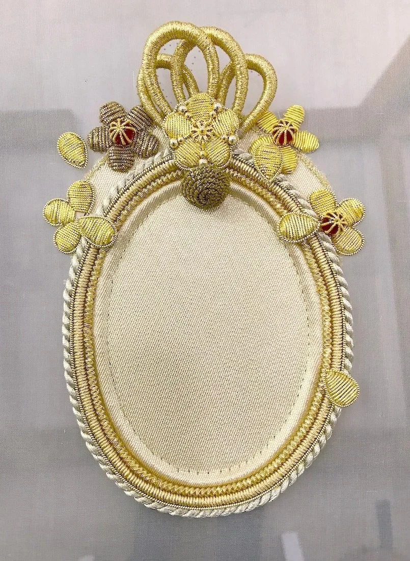 The finished goldwork oval with its crown of loops and flowers.